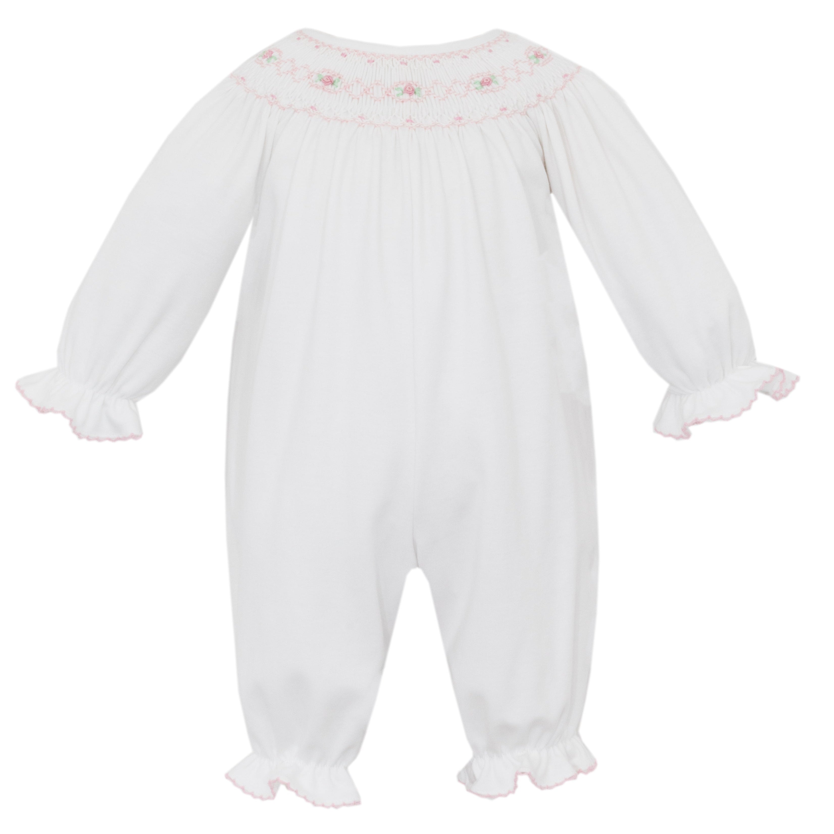 White baby romper with pink smocked details on a white background