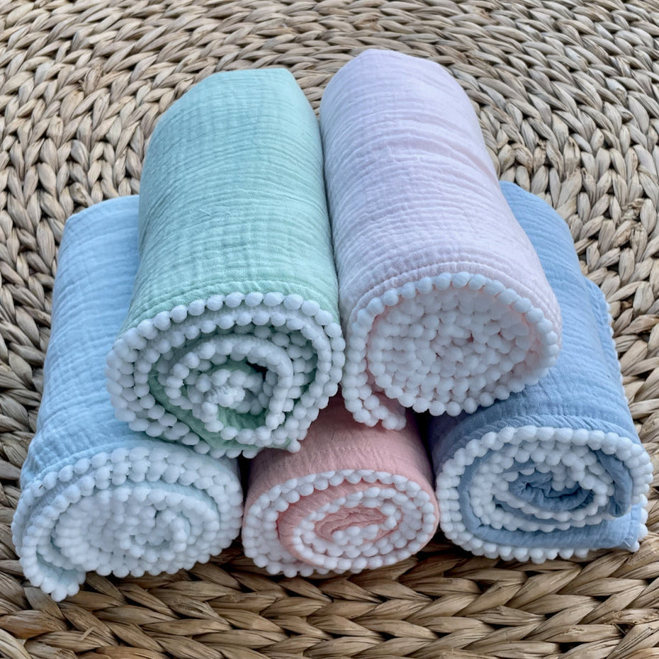 A Soft Idea Cotton Muslin Swaddle Blanket with Pom Poms