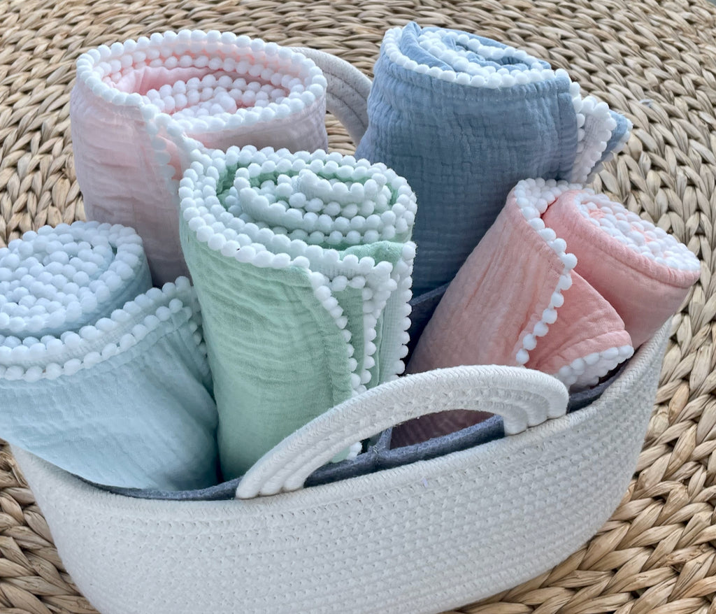A Soft Idea Cotton Muslin Swaddle Blanket with Pom Poms